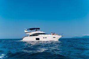 Tourists relaxing and sunbathing on the deck of a private charter boat in Tulum, enjoying the tropical weather