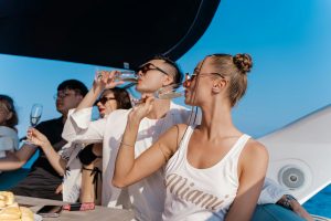 Group of friends enjoying drinks on a luxury yacht in Tulum, celebrating together under the sun.