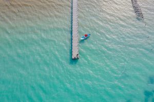 Small boat anchored near Punta Allen with clear blue water and coral reef in the Sian Ka’an Biosphere Reserve.