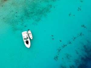 Two yachts resting on calm blue water in Tulum during the dry season